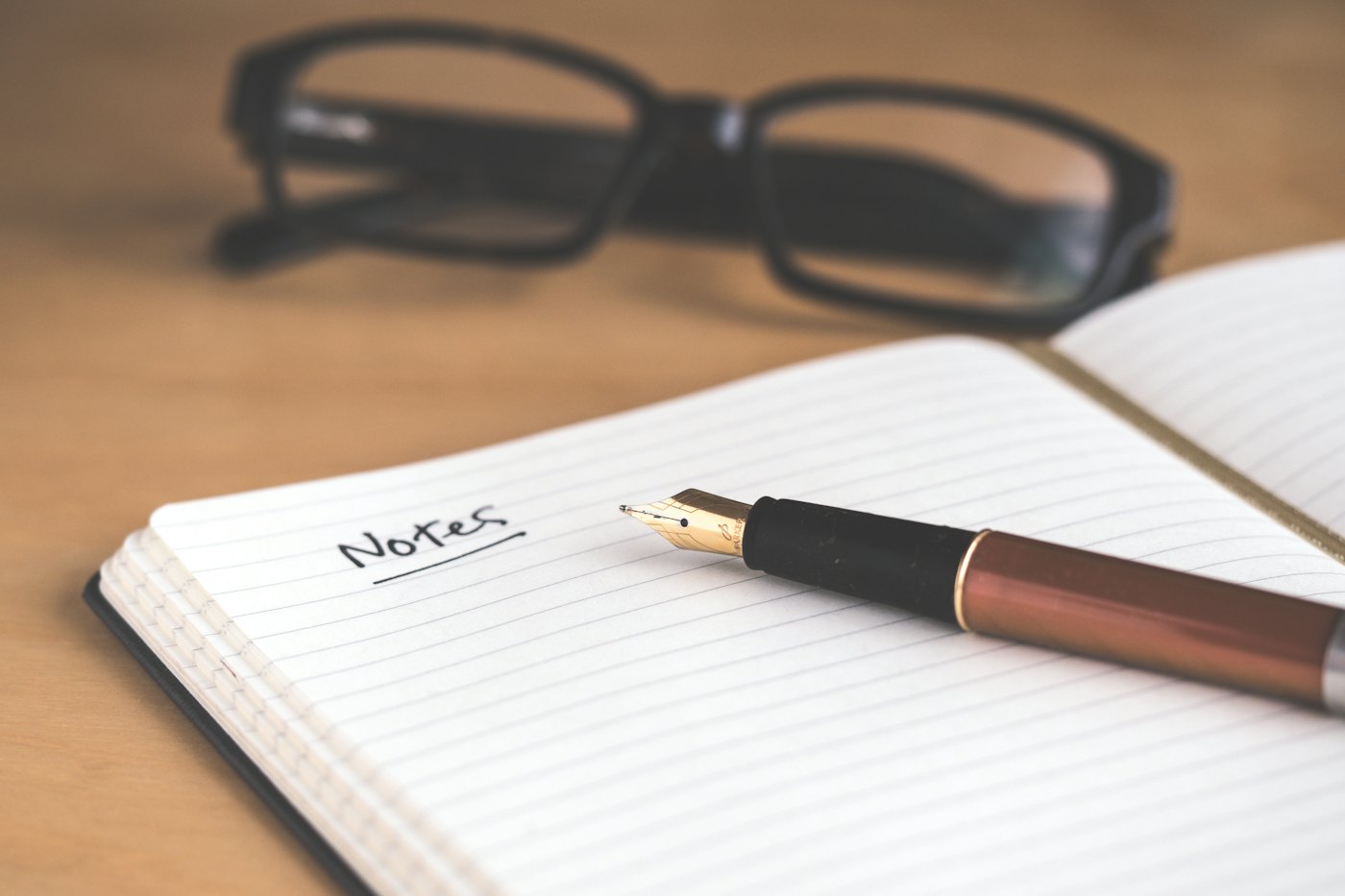 An open notebook with a fountain pen resting on the page, ready for handwritten notes — the working surface of a planning session.